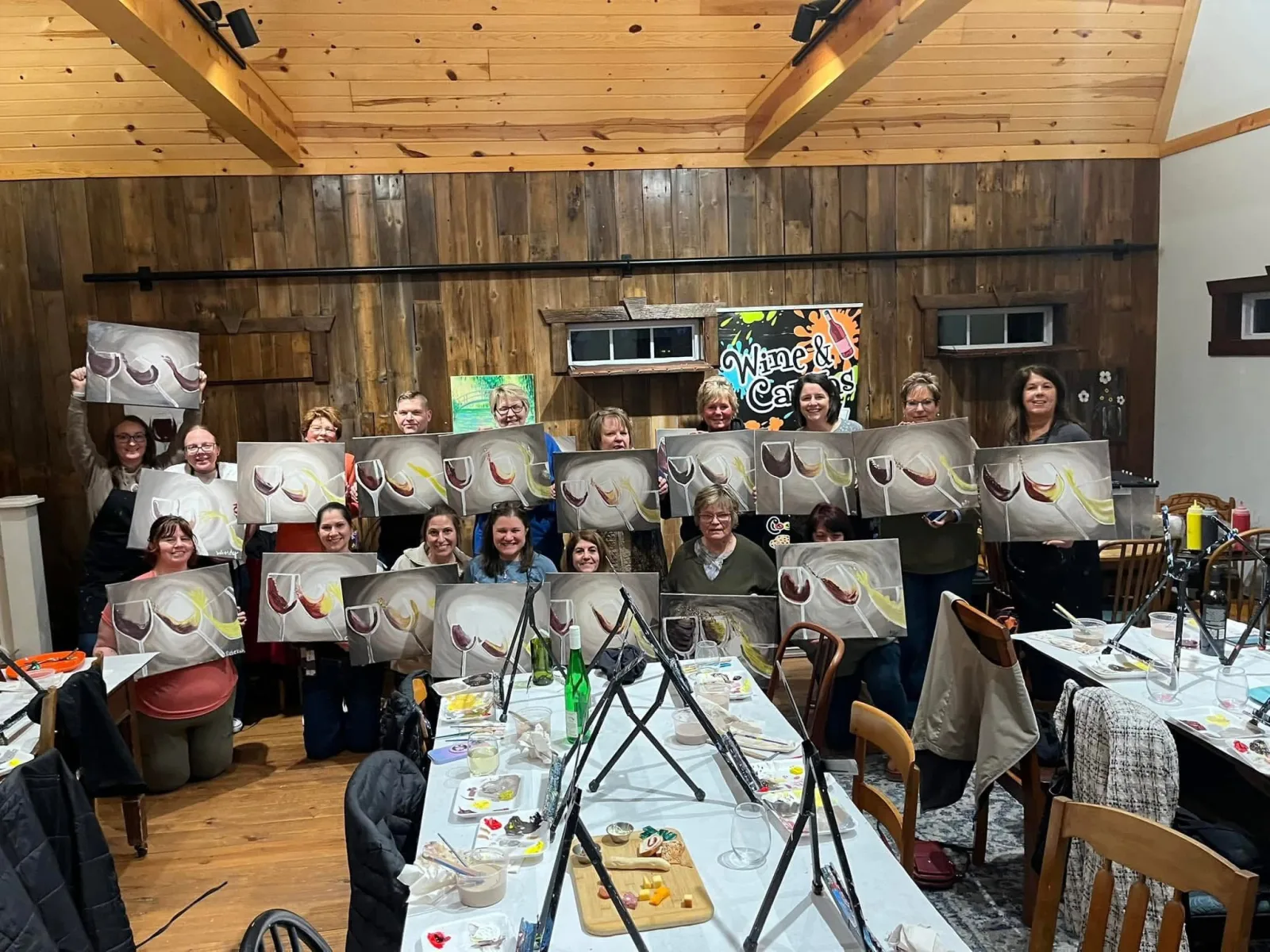 Wine & Canvas guests displaying their finished paintings at The Mockingbird